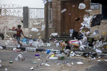 Un niño palestino camina mientras el viento en una tormenta de arena arrastra la basura en Gaza, el 1 de junio de 2023.