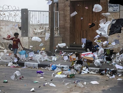 Un niño palestino camina mientras el viento en una tormenta de arena arrastra la basura en Gaza, el 1 de junio de 2023.