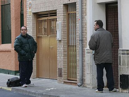Dos familiares de la chica asesinada en la puerta de su casa, el lugar en el que ocurrió el suceso.