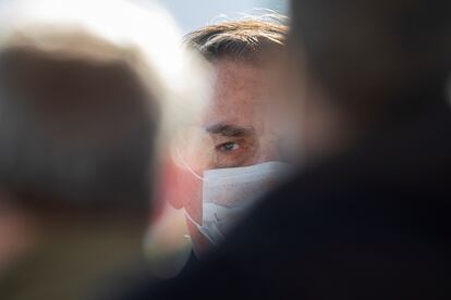 O presidente Jair Bolsonaro entre apoiadores em frente ao Palácio da Alvorada.