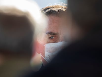 O presidente Jair Bolsonaro entre apoiadores em frente ao Palácio da Alvorada.