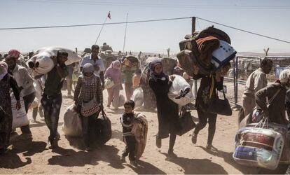 Refugiados kurdos sirios cruzan hacia Turquía desde Siria, cerca de la ciudad de Kobani, en 2014.