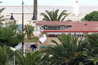 Efectivos policiales inspeccionan los daños en la caseta de la residencia del BBVA en Villajoyosa tras el atentado.