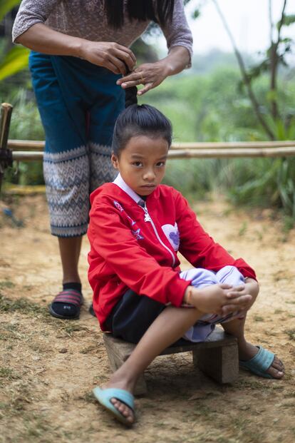 Khamphout peina a Oi, la hermana mayor de Kum, antes de ir a la escuela.