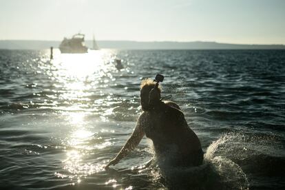 Un hombre porta una cámara acuática durante el baño tradicional de Año Nuevo en el mar Adriático, el 1 de enero de 2017 en Portoroz (Eslovenia).