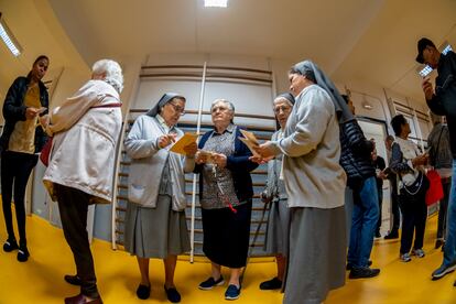 Varias personas hacen cola para ejercer su derecho al voto en el colegio electoral de Corazón de María, en Madrid. 
