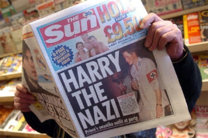 Un lector ojea 'The sun', en cuya portada aparece la image del príncipe Harry disfrazado de oficial nazi.