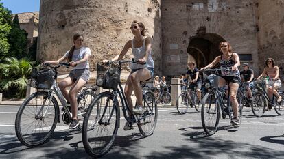 Varias personas pedalean con sus bicicletas por el centro de Valencia.