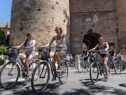 Varias personas pedalean con sus bicicletas por el centro de Valencia.