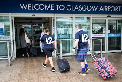 Unos viajeros en la entrada del aeropuerto de Glasgow, Escocia, Reino Unido.