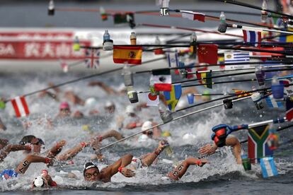Nadadores alcanzan las botellas de bebidas mientras compiten en una carrera en aguas abiertas del Campeonato Mundial de Natación de Yeosu (Corea del Sur), el 16 de julio.