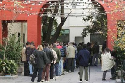 Un grupo de personas sin hogar aguarda para acceder al comedor del centro de acogida de San Isidro (Madrid).