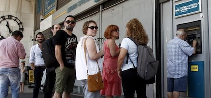 Varias personas hacen cola para retirar dinero de un cajero autom&aacute;tico en una sucursal del Banco Nacional de Grecia, en Atenas. 