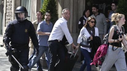 Turistas con su maleta, ayer en medio de los incidentes en Mallorca con paseo de Gr&agrave;cia.