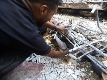 Un hombre intenta rescatar a una persona atrapada bajo los escombros de un edificio alcanzado por un ataque israelí en Ciudad de Gaza, este miércoles.