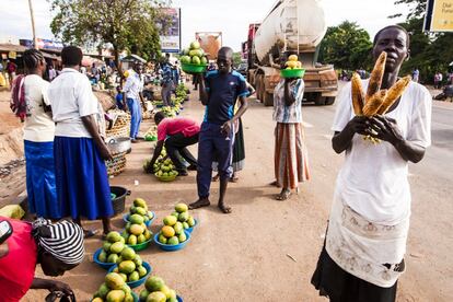 Una mujer intenta vende maíz a la parrilla en un mercado callejero de Arua.