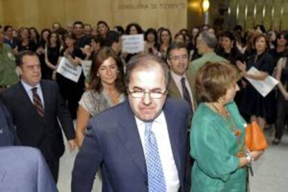 El presidente de la Junta de Castilla y León, Juan Vicente Herrera (c), es recibido con los abucheos y palmeos de cerca de un centenar de funcionarios que espontáneamente celebran los viernes de negro para defender la dignidad de los empleados públicos y el empleo.