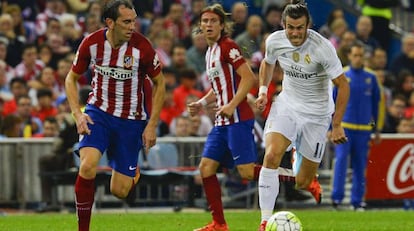 Diego Godin, defensa del Atl&eacute;tico de Madrid, corre a por un bal&oacute;n junto al delantero del Real Madrid, Gareth Bale.
 