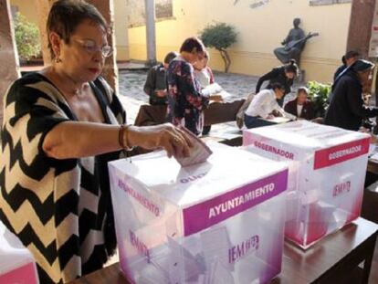 Una ciudadana deposita su voto en una mesa electoral en Michoac&aacute;n.