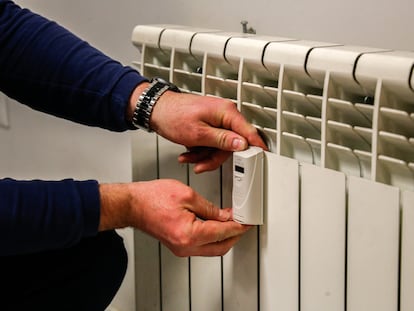 Un técnico instala un contador individual en un radiador de una vivienda en Madrid.