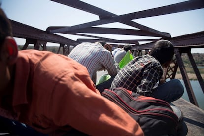  A los jóvenes de a bordo les divierte tener que agachar la cabeza para librar con más holgura el puente sobre el río Kuno. Antes, el maquinista ha reducido la velocidad hasta casi detener el tren.