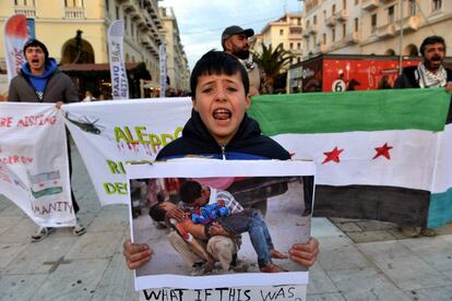 Un niño sirio sostiene una fotografía de un niño muerto en Siria durante una manifestación de apoyo a los ciudadanos de Alepo, en Salónica (Grecia), el 16 de diciembre de 2016.