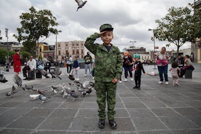 Una niña vestida con el uniforme del Ejercito Mexicano posa para la cámara.