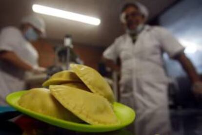 Fotografía de dos trabajadores de la empresa Maquiempanadas, en la ciudad de Manizales (Colombia).