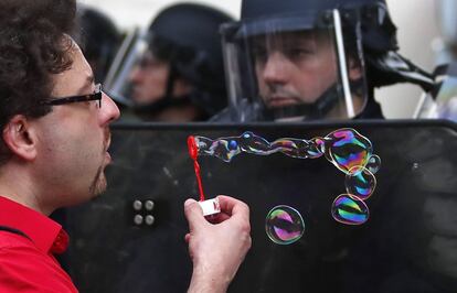 Un manifestante hace pompas de jabón ante efectivos de la policía antidisturbios, durante una protesta convocada contra la reforma laboral del Gobierno socialista en París, Francia.