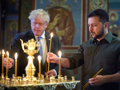 Boris Johnson (a la izquierda) y Volodímir Zelenski encienden velas en el monasterio de San Miguel de las Cúpulas Doradas, este viernes en Kiev.