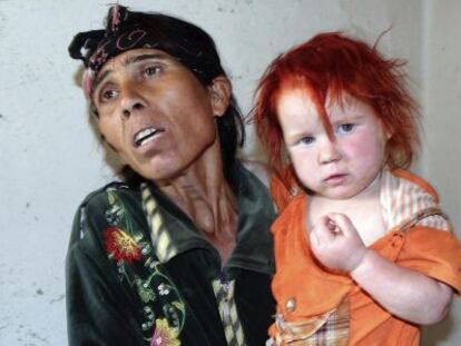 La supuesta madre de la niña conocida como el 'Ángel rubio' coge a otra de sus hijas en su domicilio de Nikolaevo (Bulgaria) hoy.