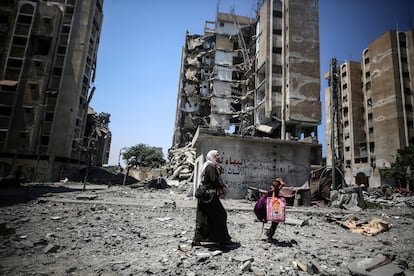 Una mujer camina por su hija por una calle bombardeada de Nuseirat, el pasado 21 de julio.