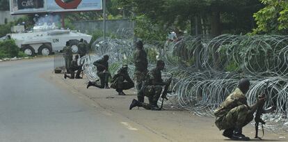 Soldados de las Fuerzas Nuevas, antiguos rebeldes partidarios de Ouattara, protegen el hotel donde se refugia el líder opositor, al tiempo que cascos azules patrullan la zona.