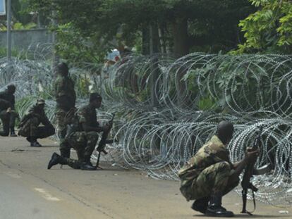 Soldados de las Fuerzas Nuevas, antiguos rebeldes partidarios de Ouattara, protegen el hotel donde se refugia el líder opositor, al tiempo que cascos azules patrullan la zona.