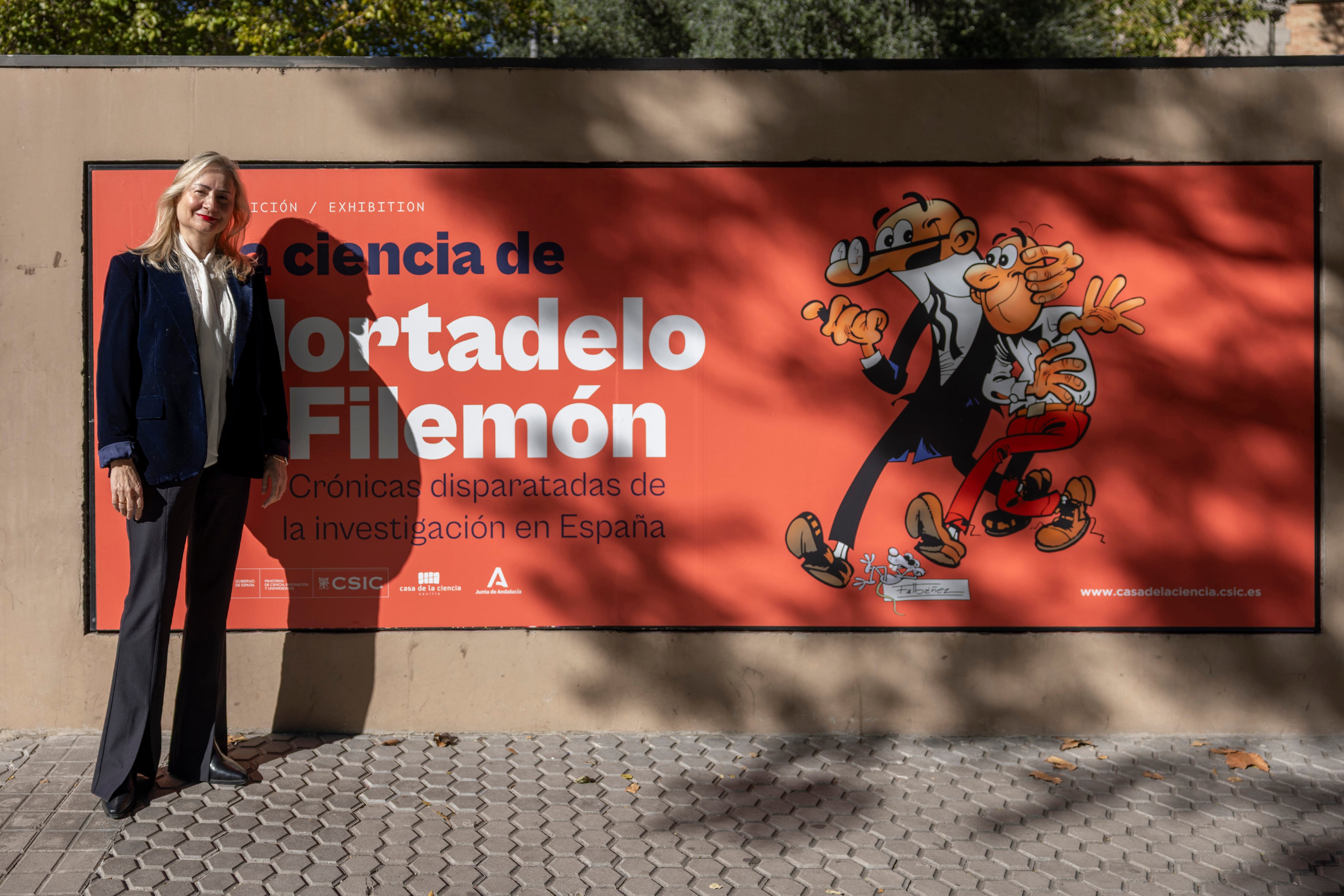 Pura Fernández, vicepresidenta de Cultura Científica y directora de la Editorial CSIC, junto al cartel de la exposición.