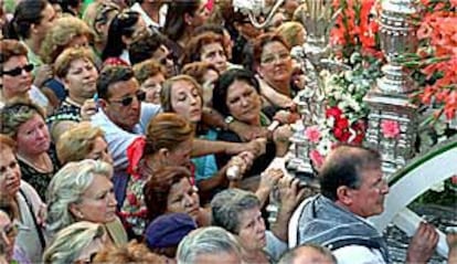 Los romeros avanzaban ayer asidos a la carreta del simpecado de Triana por las calles del barrio.