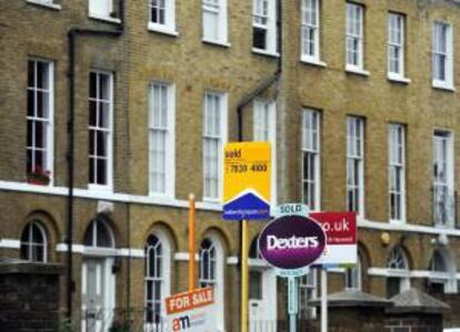 Vista de varios anuncios de casas cerca de un edificio de viviendas en Londres, Reino Unido.