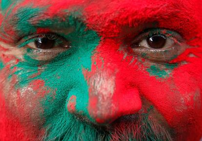 Un hindú es cubierto con polvo coloreado a las afueras de un templo durante el festival Holi en Vrindavan, India.