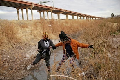 Dos personas atraviesan el río Bravo de Ciudad Juárez a El Paso (Texas).