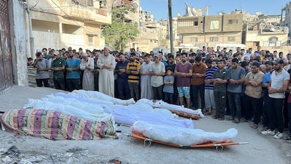 Rezo frente a cadáveres del bombardeo, en Ciudad de Gaza.