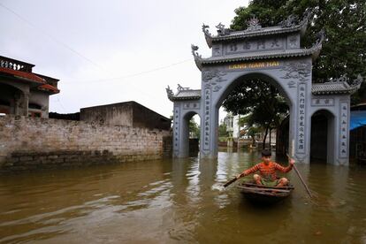 Un ni?o rema a bordo de una peque?a embarcacin por las calles de Hanoi (Vietnam), inundadas por las fuertes lluvias causadas por las tomentas tropicales.