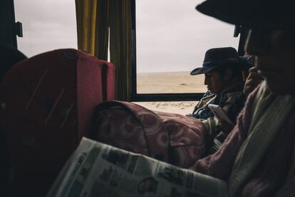 Los pasajeros leen periódicos en el autobús que cruza la frontera y conecta la ciudad peruana de Tacna con la primera ciudad chilena, Arica. Esta línea de autobús es la principal vía utilizada por los migrantes que son rebotados para intentar llegar a Chile.