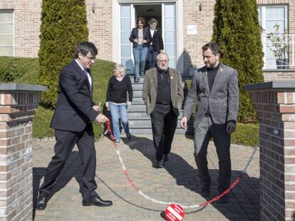 Puigdemont retira la cadena de la entrada de su casa de Waterloo, en febrero de este año.