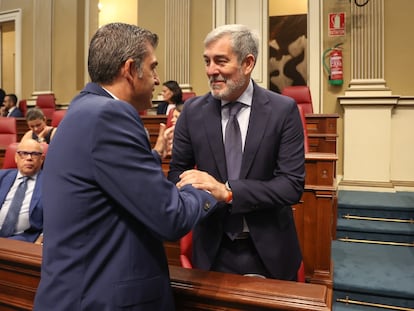 El presidente del PP de Canarias, Manuel Domínguez, a la izquierda, felicita al secretario general de Coalición Canaria, Fernando Clavijo, durante el debate de investidura, este miércoles.