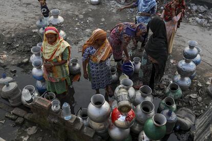 Un grupo de mujeres llena jarras con agua potable en un suministro en un barrio pobre de Dhaka (Bangladesh).