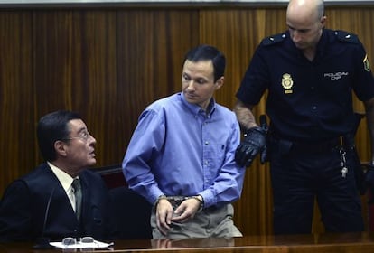 Jos&eacute; Bret&oacute;n (c) talks with his lawyer before being led away by police after hearing the guitly verdict.