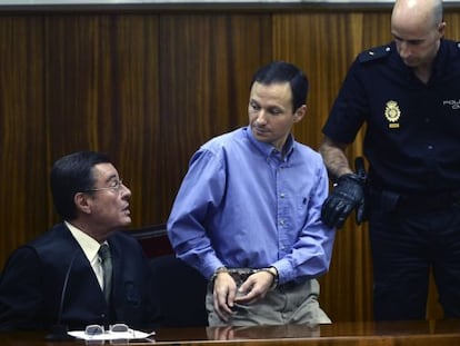 Jos&eacute; Bret&oacute;n (c) talks with his lawyer before being led away by police after hearing the guitly verdict.