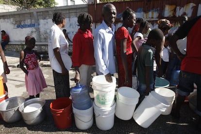 Um grupo de haitianos vítimas do terremoto faz fila para pegar água no bairro marginal de Citei du Soleil, em Porto Príncipe (22/01/2010).