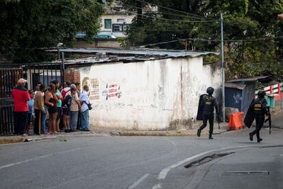 Miembros de Comando Nacional Antiextorsion y Secuestro CONAS corren en una calle con armas largas en Caracas (Venezuela). 