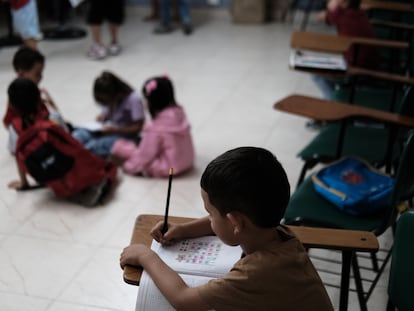 Un grupo de niños desplazados realiza tareas para aprender a escribir